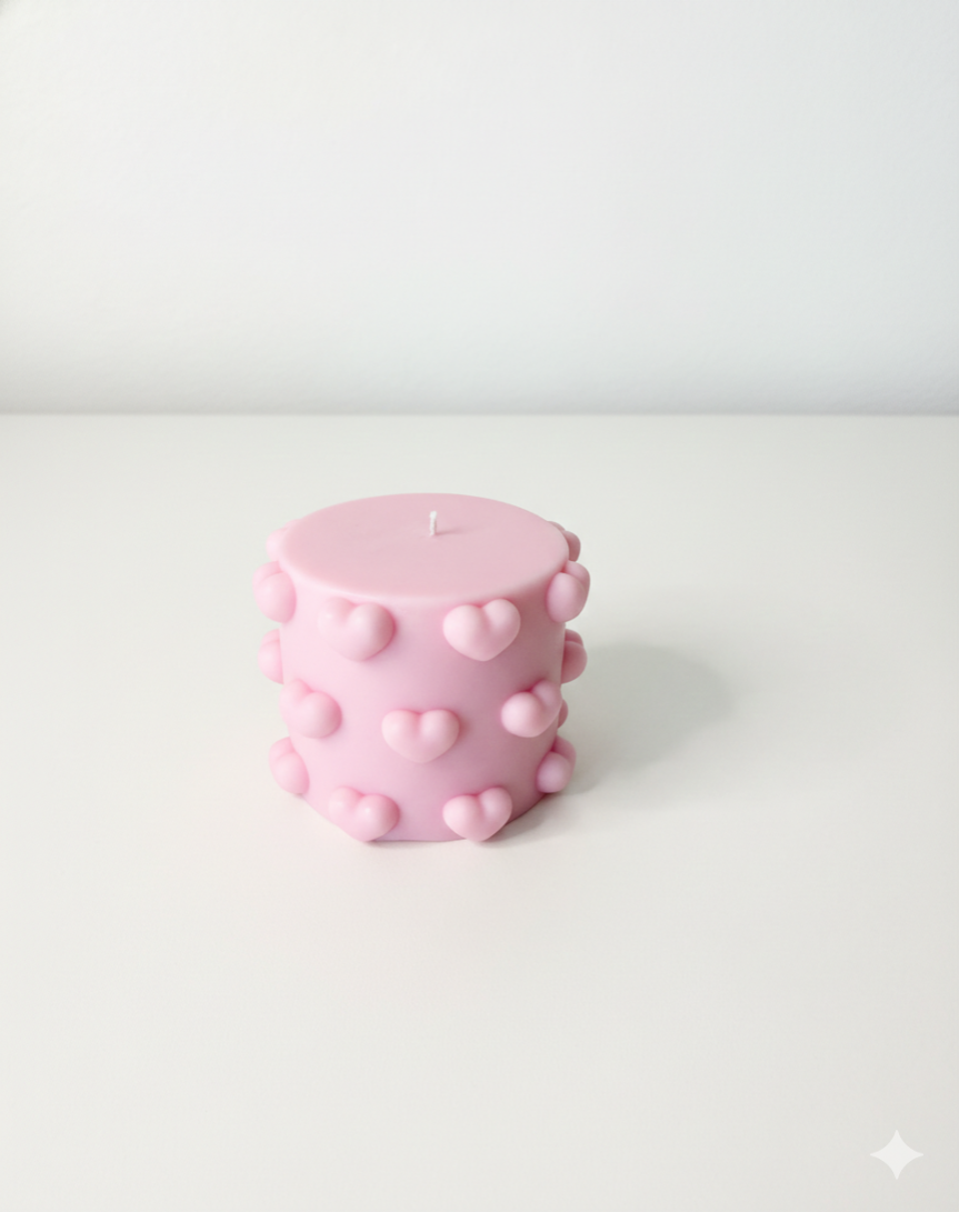 Pink textured candle on a white background